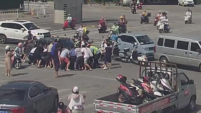柳州六旬老人被卷入车底，20多位市民抬车救人