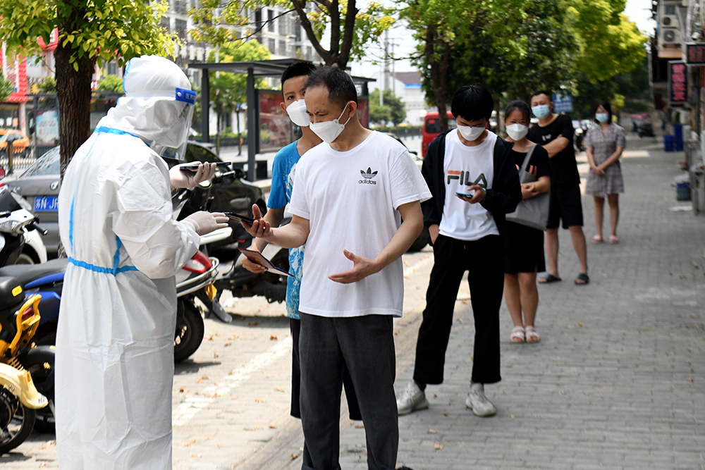 7月3日，在安徽省宿州市泗县虹城街道一小区，居民排队等候接受核酸采样。新华社  图