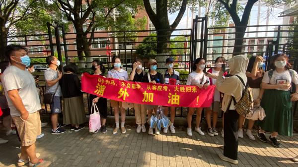 7月7日，上海外国语大学附属浦东外国语学校的已经被保送的高三学生组成陪考团，为高考学子加油。澎湃新闻记者 巩汉语 图