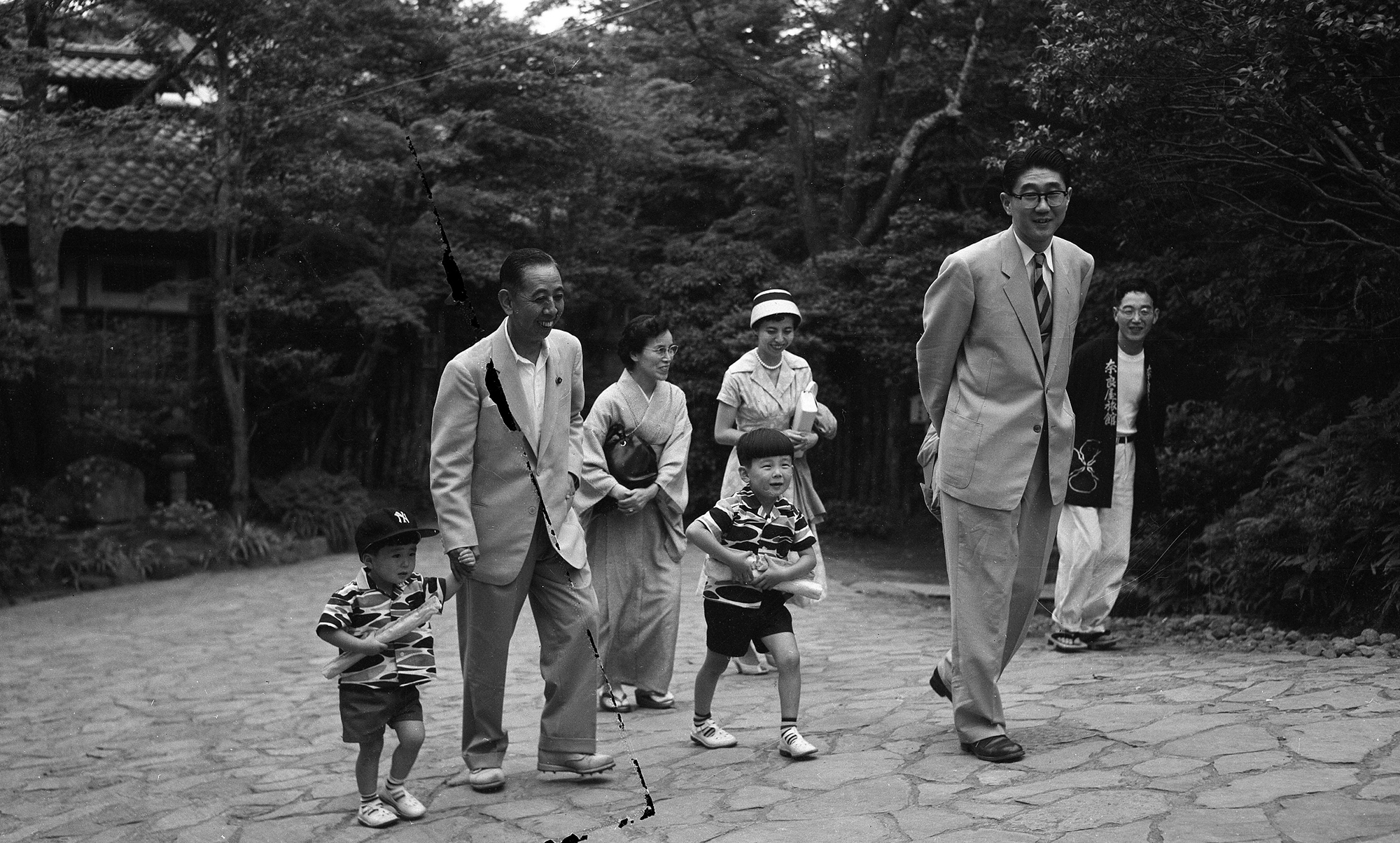 1957年7月7日，日本箱根，前日本首相岸信介（左二）牵着他的孙子安倍晋三（左一）与妻子凉子（左三），还有女婿安倍晋太郎（右二）、女儿安倍洋子（右三），孙子宽信在一起。