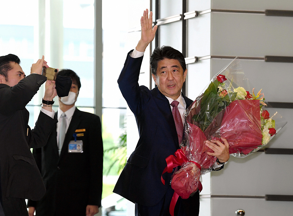 当地时间2020年9月16日，日本东京，即将卸任的日本首相安倍晋三最后一次在首相官邸举行内阁会议后，从工作人员那里收到鲜花。