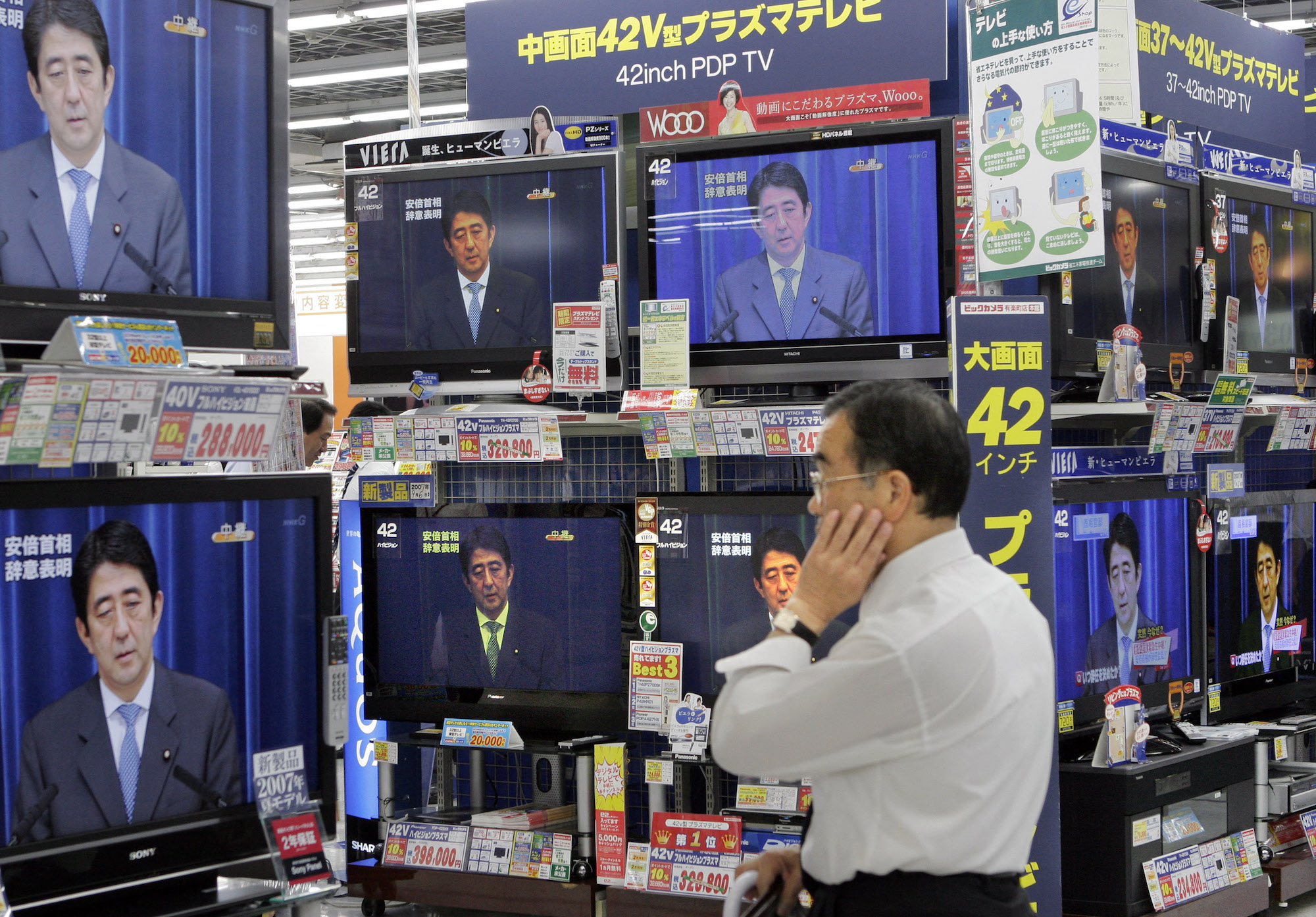 当地时间2007年9月12日，一名日本人在电视直播中观看首相安倍晋三宣布辞职。