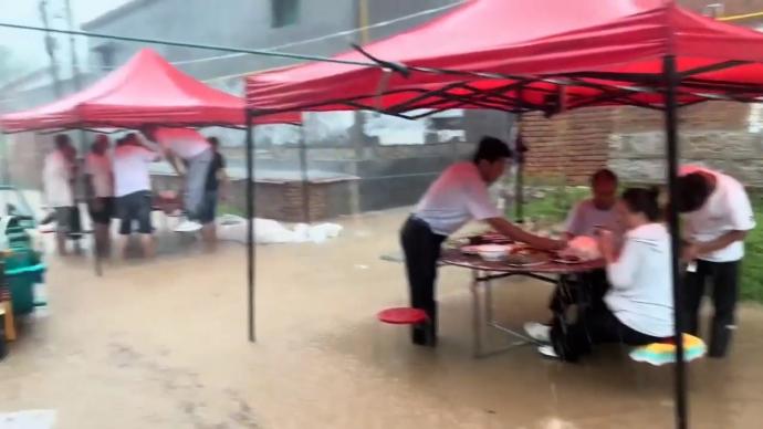 参加葬礼遇暴雨，宾客积水中围坐吃席