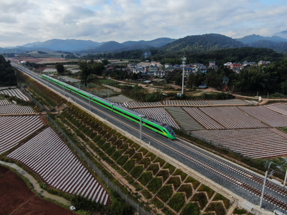 2022年1月3日，列车行驶在位于云南西双版纳傣族自治州景洪市境内的中老铁路上（无人机像片）。新华社 贵府图