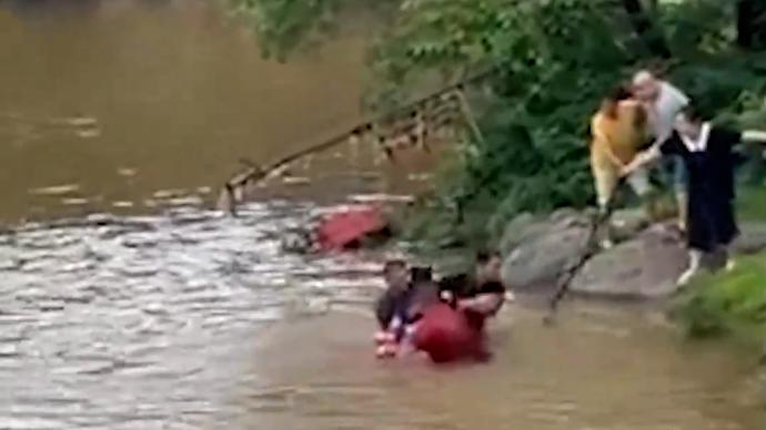 男孩不慎落水被急流越冲越远，三名男子奋不顾身跳水救人
