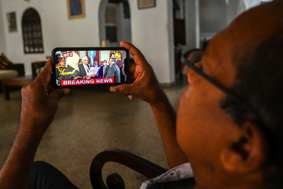 当地时间2022年7月21日，斯里兰卡首都科伦坡，民众在手机上观看维克拉马辛哈宣誓就职斯里兰卡总统。VCG111392928409.jpg