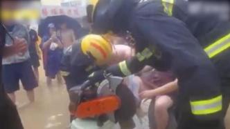 暴雨中女子腿卡下水道滤网，消防助其脱困后抬上消防车送医