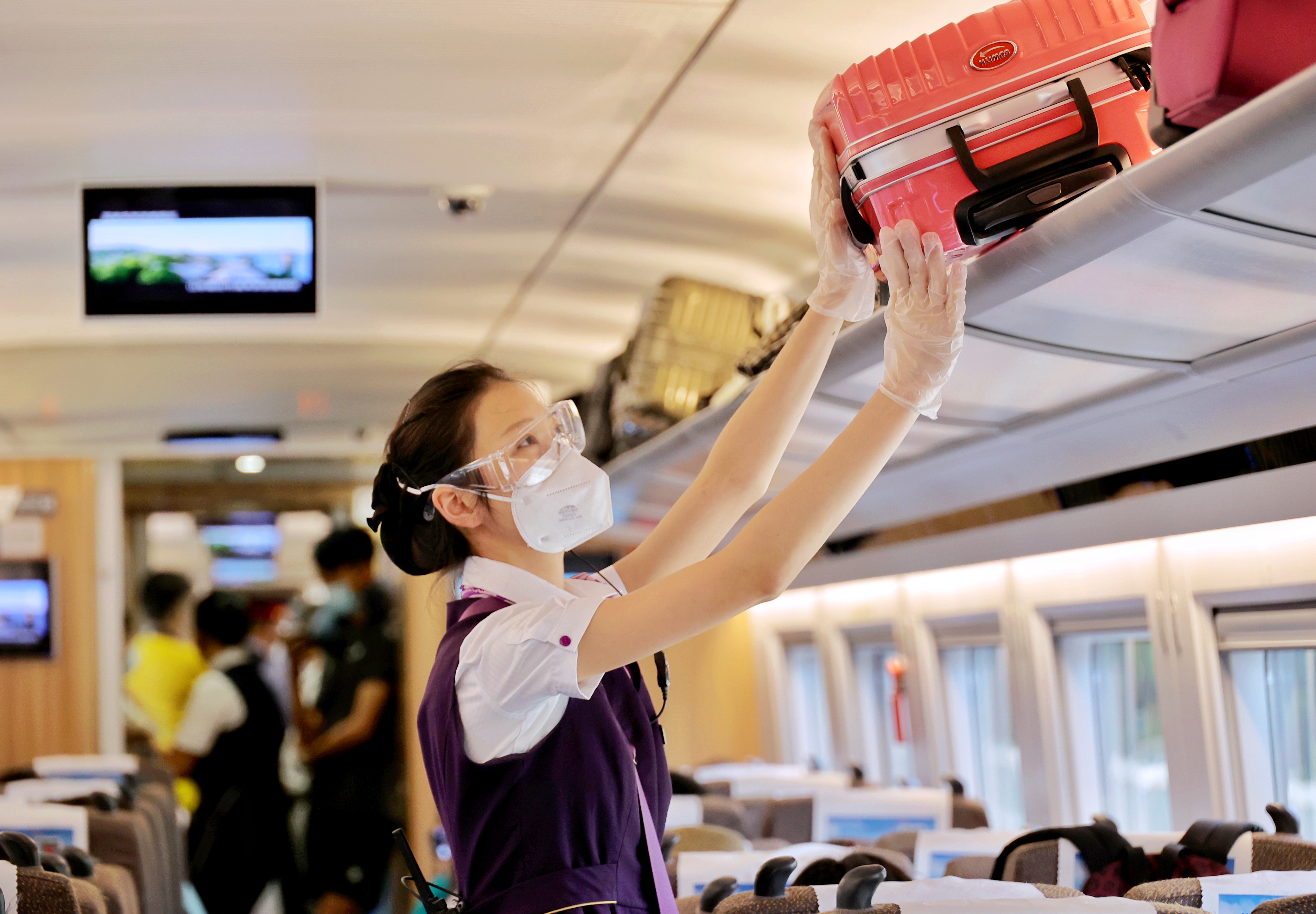 g7714次列车乘务员在车厢内整理行李架物品.周围 摄