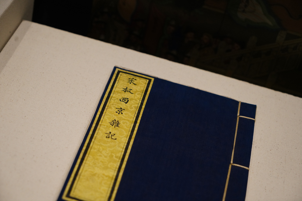 展览展示的一册《西京杂记》，石青色的绢制书衣、黄绫题签书名，端庄雅正