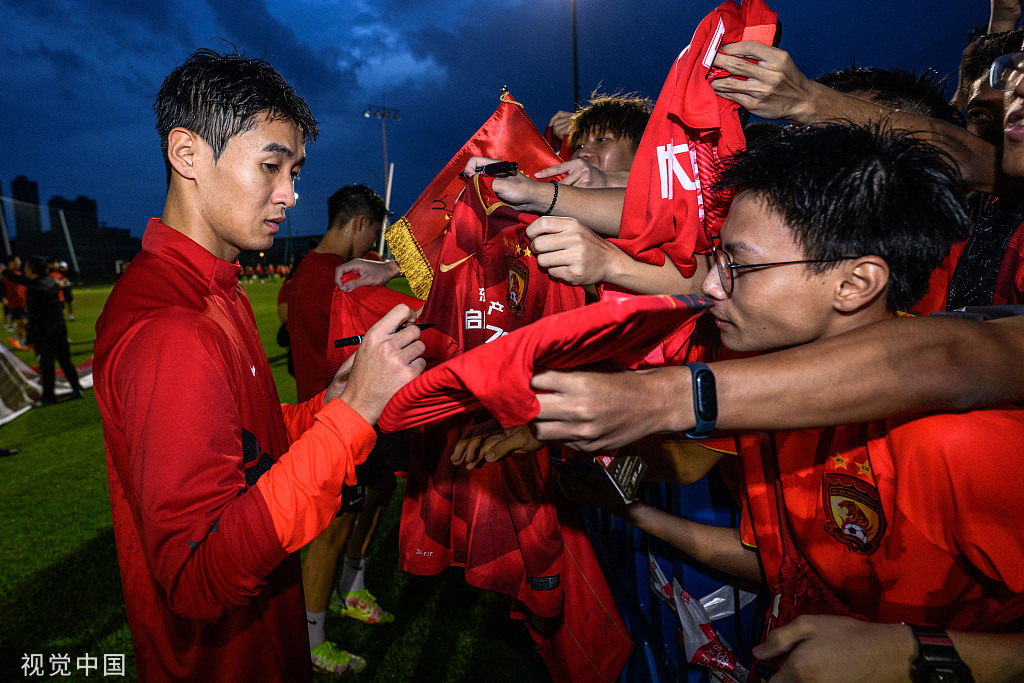 韦世豪为广州队球迷签名。