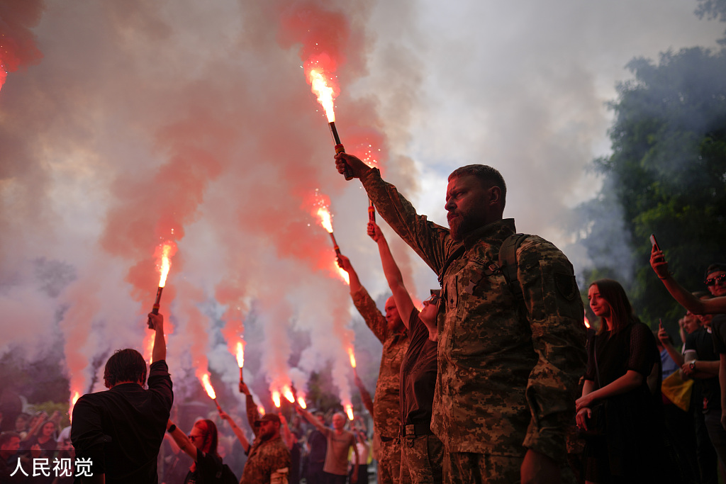 当地时间2022年6月18日，乌克兰基辅，士兵们手持照明弹参加激进分子和士兵罗曼·拉图什尼的葬礼。人民视觉 图