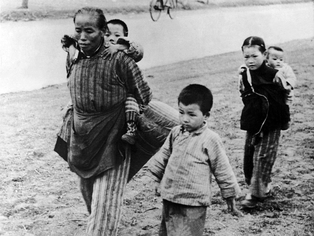 1937年11月19日，上海淞沪会战期间，一个中国老妇人带着几个孩子向租界走去。