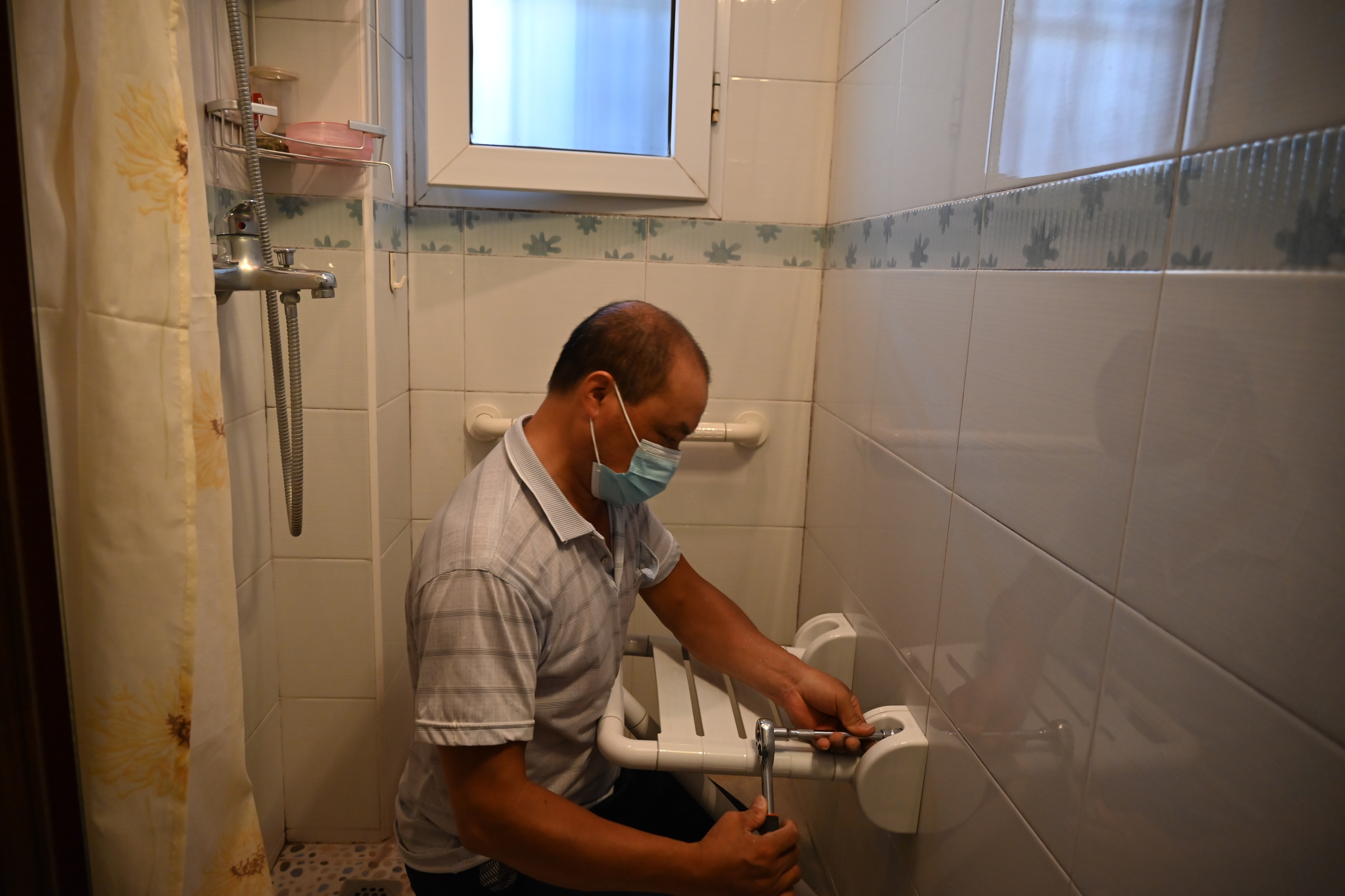 施工人员正在对老年人家庭进行适老化改造.龙钢 摄