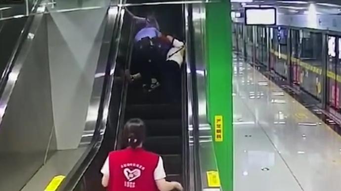 家长与孩子一起滚下扶梯，辅警冲上去用身体挡住