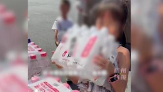 杭州妈妈带着孩子给街头爱心冰箱送水