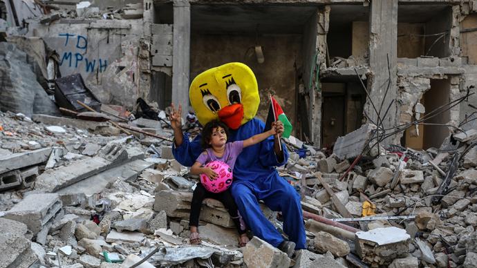 早安·世界｜巴以停火后，儿童与志愿者在房屋废墟上嬉戏