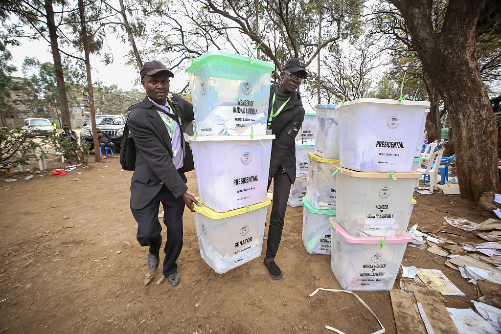 当地时间（shijian）2022年8月11日，肯尼亚内罗毕，独立选举和边界委员会（IEBC）官员在Mathare选区计票中心拿着投票箱。视(shi)觉中国 图