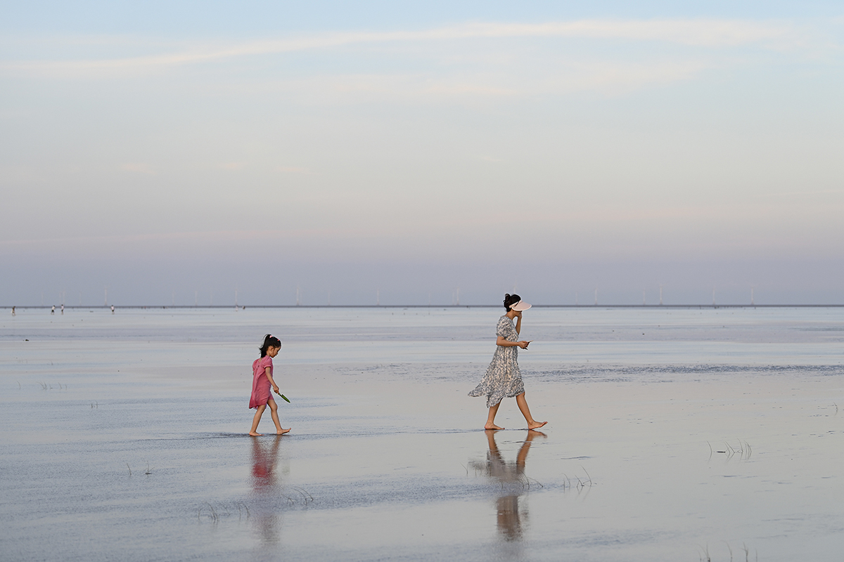 2022年8月14日,上海,东海,市民在滩涂上玩水消暑。澎湃新闻(xinwen)记者 朱伟辉 图