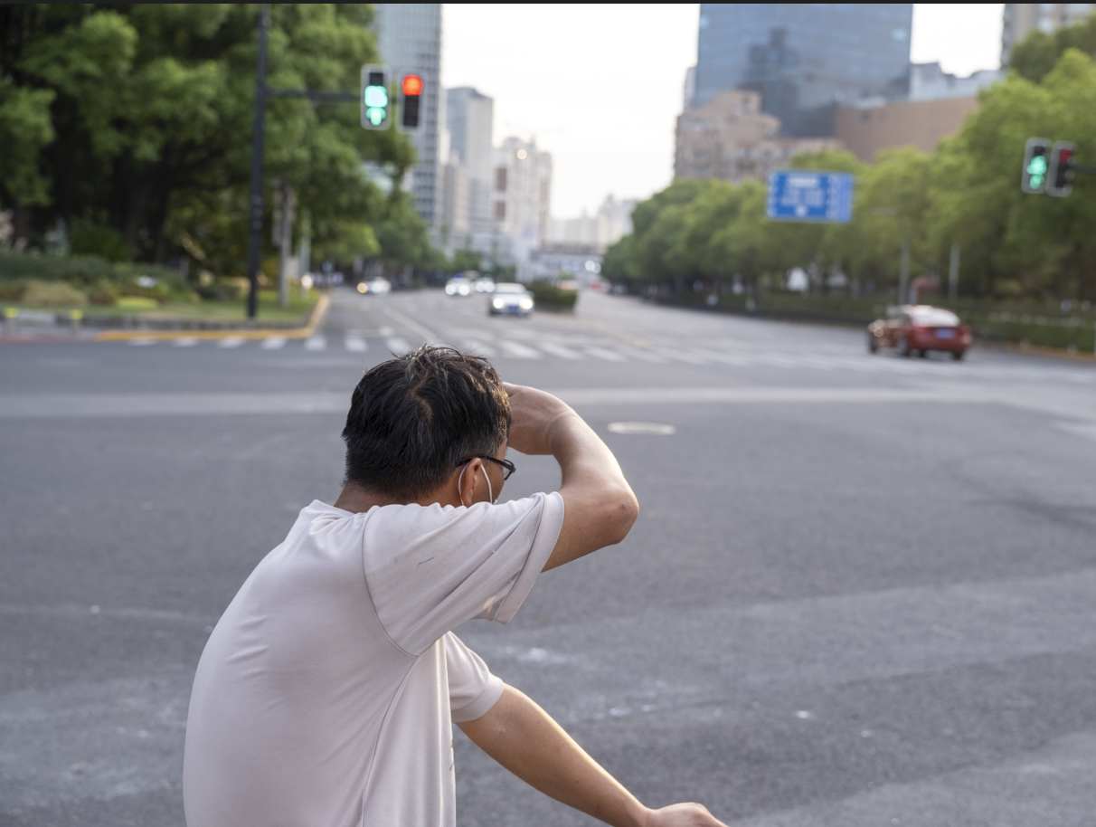 2022年8月14日,一名男子用手遮挡夕阳。上海昨日42摄氏度,骄阳似火。澎湃新闻(xinwen)记者 许海峰 图