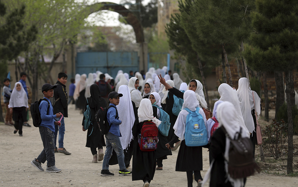 当地时间（shijian）2021年3月27日，阿富汗喀布尔，阿富汗女学生走进学校。虽然阿富汗临时政府教育部此前宣布，全国所有中小学将重新开放，但教育部当天再次发布声明表示，女子初中和高中仍将关闭，直至另行通知。声明提到，与着装有关的(de)问题是(shi)学校关闭的(de)一个原因。