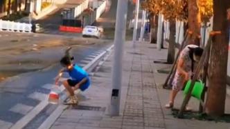街道水管爆裂，妈妈带着孩子接水浇行道树