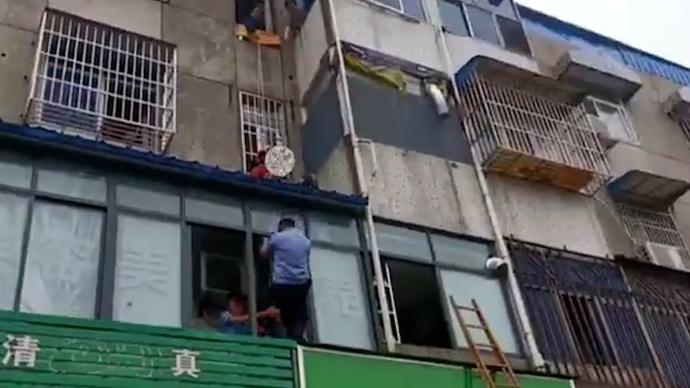 消防員與民警合力，成功救下懸空而坐的老人
