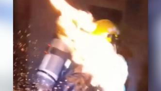 消防员徒手拎着燃烧的煤气罐冲出火场