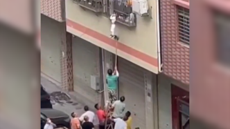 男童被卡防盗窗悬吊半空，群众合力施救