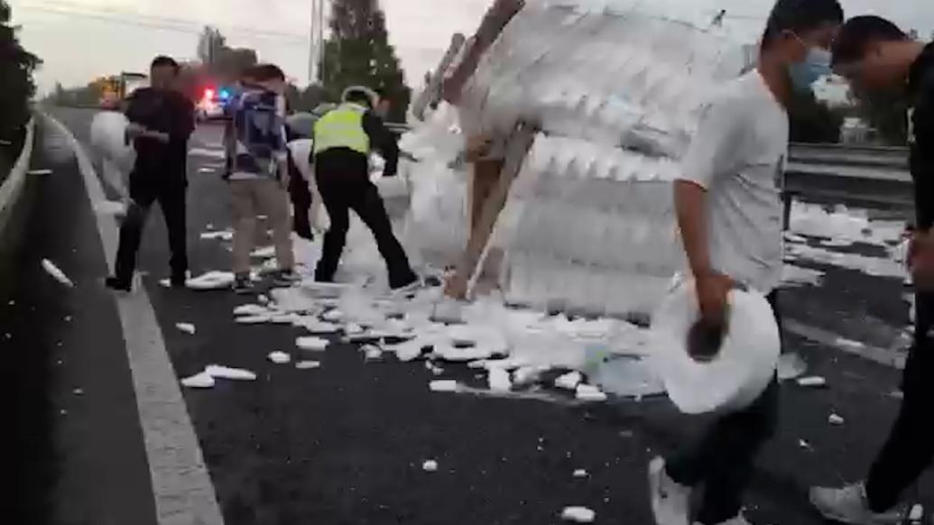 散落货物堵死高速匝道，过路市民自发当起搬运工