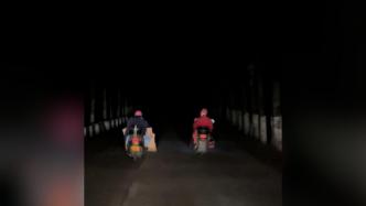 两名路人“摸黑”骑摩托，后车司机放慢车速帮照明
