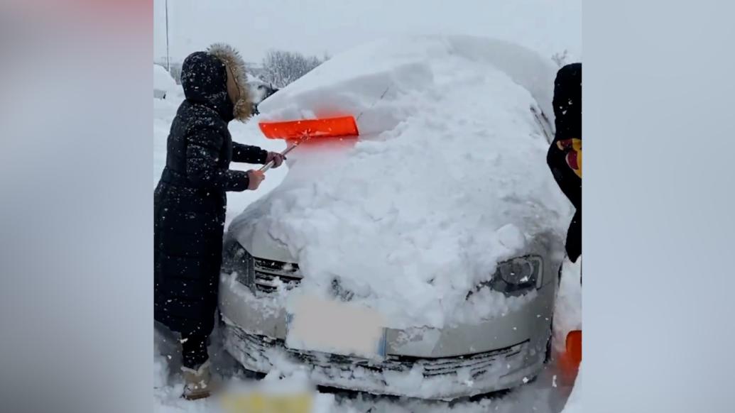 威海普降大雪，司机想开车先得从雪堆里挖出车