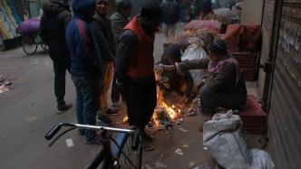 印度首都新德里气温创今冬以来新低，民众在街头生火取暖