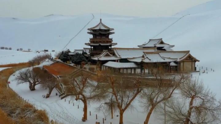 甘肃敦煌迎来降雪，鸣沙山下雪落如画