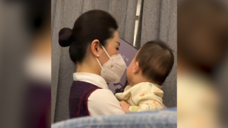 乘务员飞机上暖心帮乘客哄宝宝