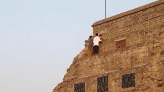 “熊孩子”攀爬城墙被困10米高处，两名00后小伙爬墙施救