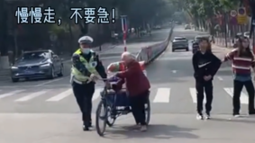 老人推三轮车过马路被困车流中，执勤民警出手相助