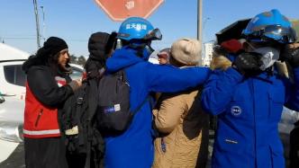 蓝天救援队女队员拥抱哭泣的土耳其阿姨，阿姨用衣怀为她暖手