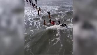 男子捞海肠时被海浪卷走，众人拉起绳子接力救援