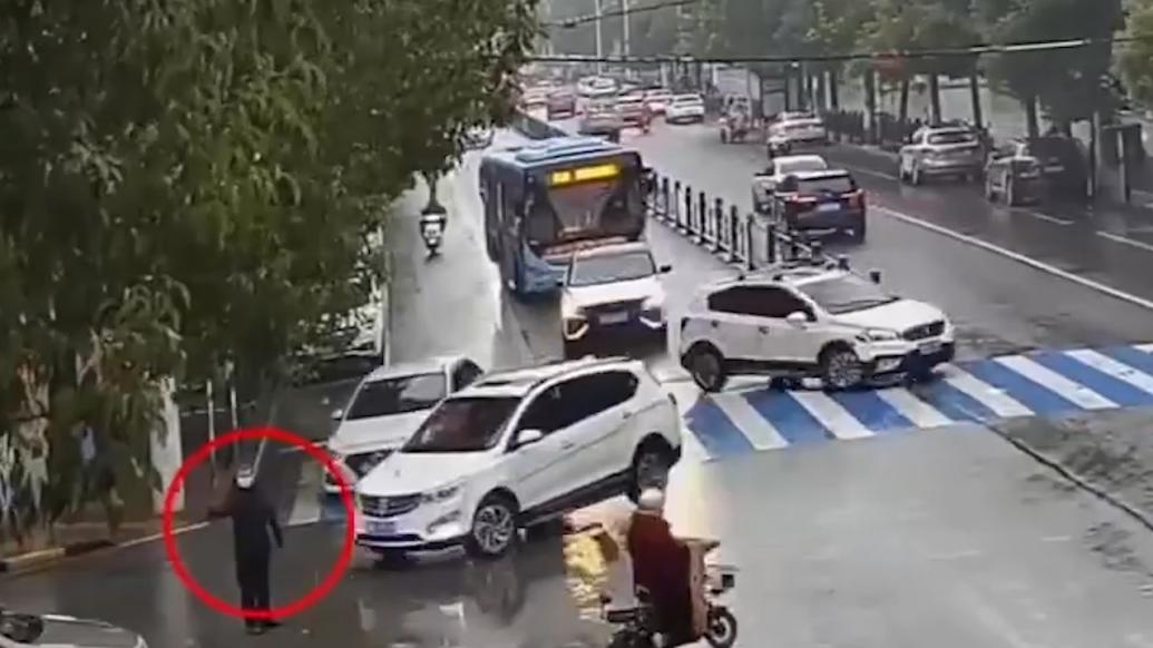 交警骑自行车上班遇堵车，站路口冒雨疏导交通十分钟排堵