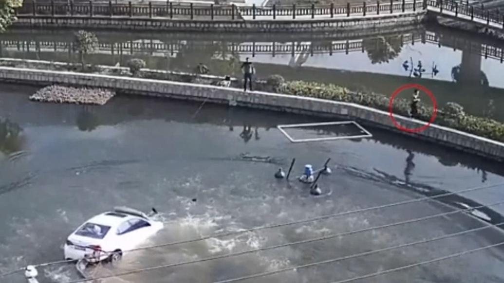 司机操作不当将车开入池塘孕妻被困，两男子跳水救人