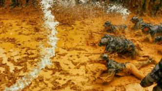 高校军训用高压水枪，学生在泥地匍匐前行