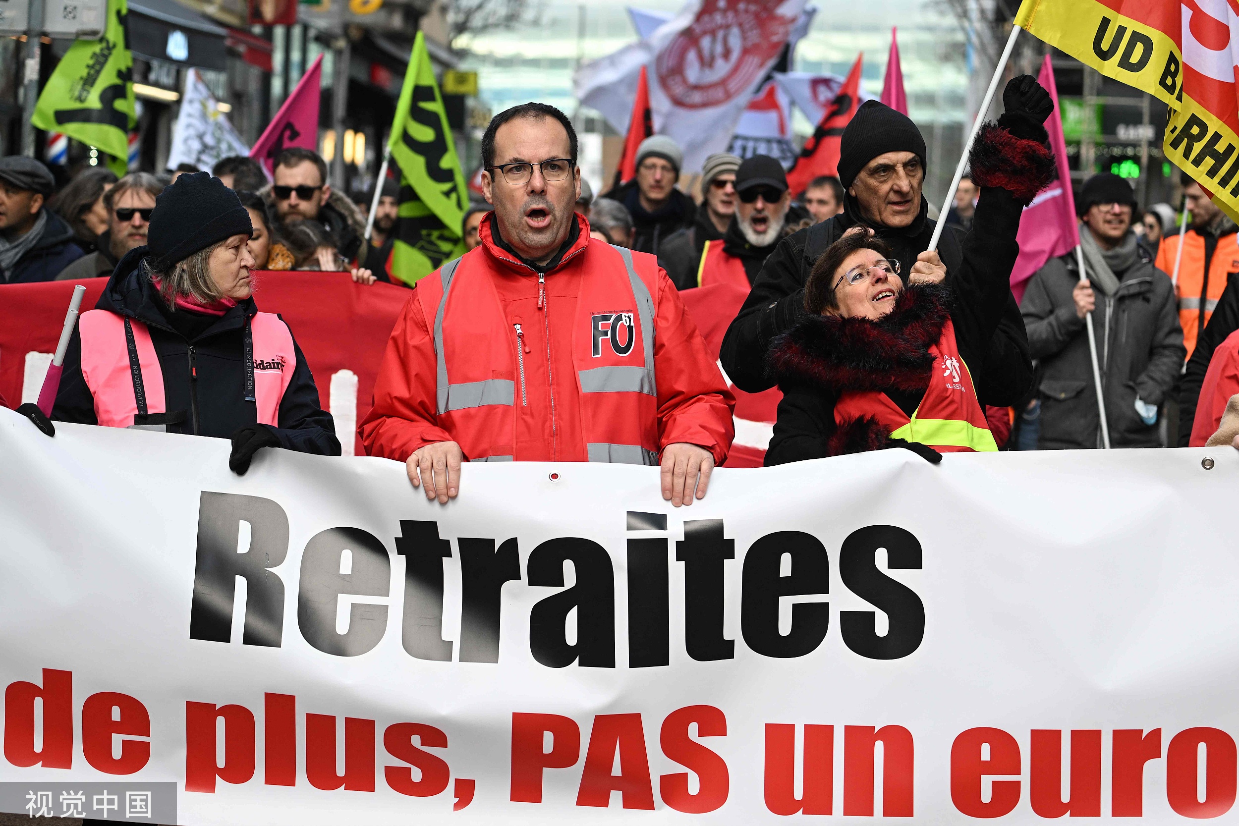 当地时间2023年3月11日，法国斯特拉斯堡，身穿法国工会Solidaires(左)、法国工人力量工会和法国总工会背心的示威者在示威活动中举着写有“退休”的横幅，这是工会呼吁的全国罢工和抗议日的一部分，抗议拟议中的养老金改革。