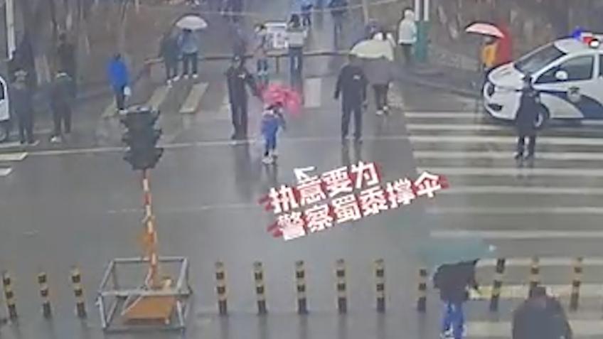 暖心！小学生雨天为护学民警撑伞