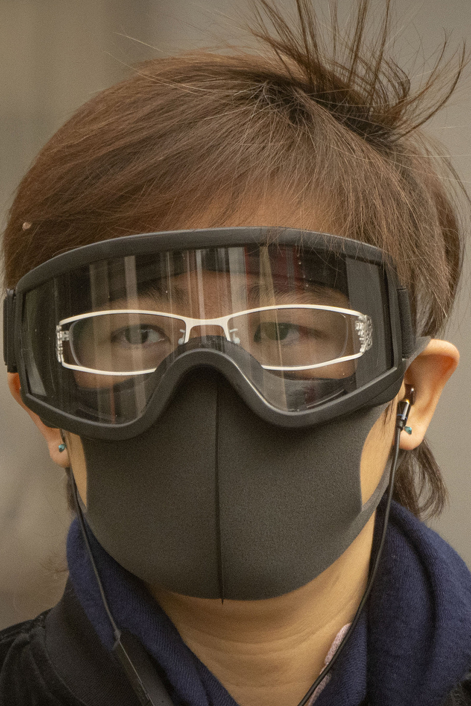 2023年3月22日，北京，一名戴着口罩和护目镜的女子走在中央商务区的街道上。.jpg