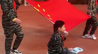 安徽12岁瘫痪男孩骑扭扭车担任国旗护旗手