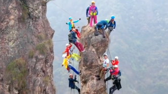 10余男女攀上细长垂直岩壁集体晃动拍视频，村民：周末天天有人爬