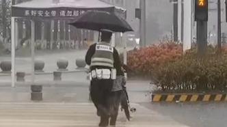 午后风雨交加，值守交警为没带伞的路人撑伞