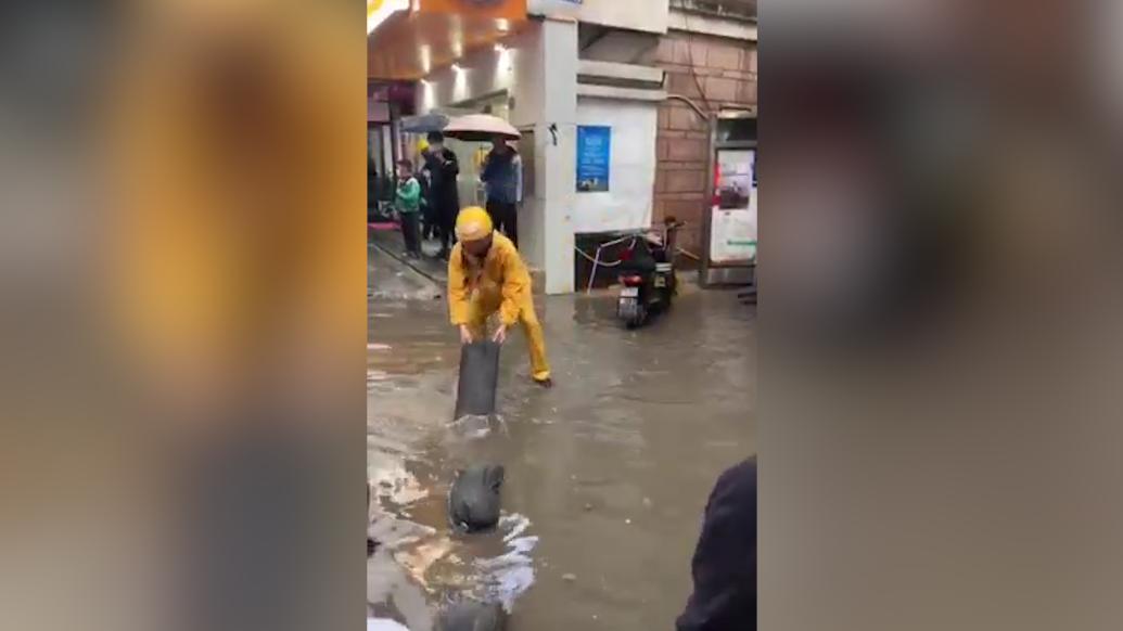 暴雨渍水，外卖小哥主动搬沙袋铺路