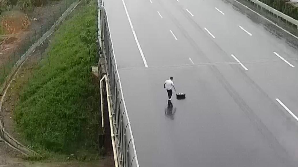 衢州一高速车道上躺着一只轮胎，热心男子冒雨推开除隐患