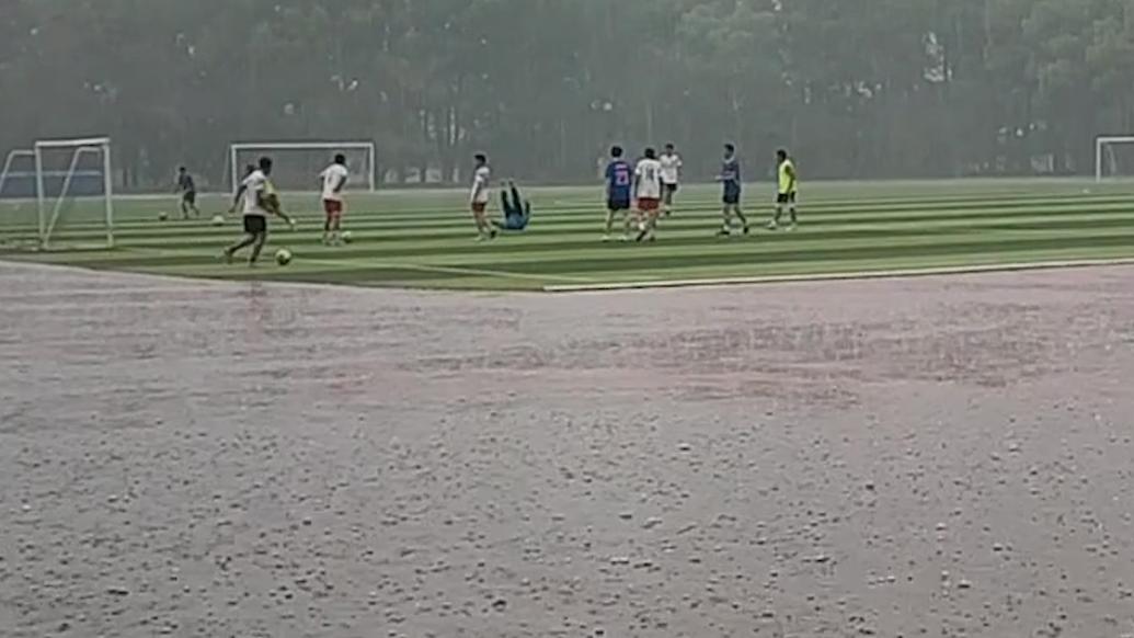 青春的味道！高校男生雨中踢足球惹同学赞叹